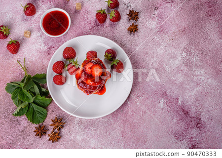 Cottage cheese pancakes with sliced strawberries and strawberry jam on a plate on a concrete background Cottage cheese pancakes with sliced strawberries and strawberry jam on a plate on a concrete background 90470333
