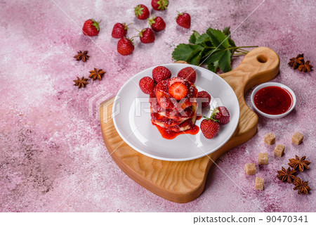 Cottage cheese pancakes with sliced strawberries and strawberry jam on a plate on a concrete background Cottage cheese pancakes with sliced strawberries and strawberry jam on a plate on a concrete background 90470341
