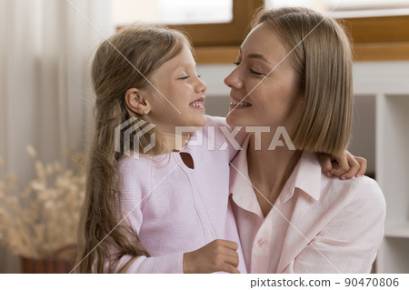 Happy young woman and little cute daughter hugging indoor Happy young woman and little cute daughter hugging indoor 90470806