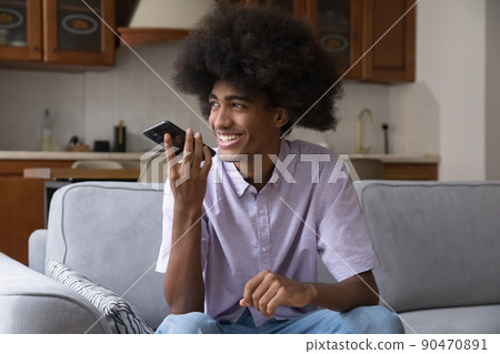 Cheerful teen guy with African retro hairdo speaking at speaker 90470891