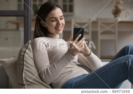 Happy dreamy beautiful millennial girl chatting online in deep thoughts 90471048