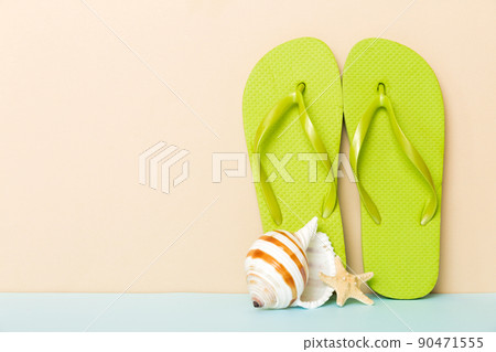 Beach accessories. Flip flops and starfish on colored background. Mock up with copy space Beach accessories. Flip flops and starfish on colored background. Mock up with copy space 90471555