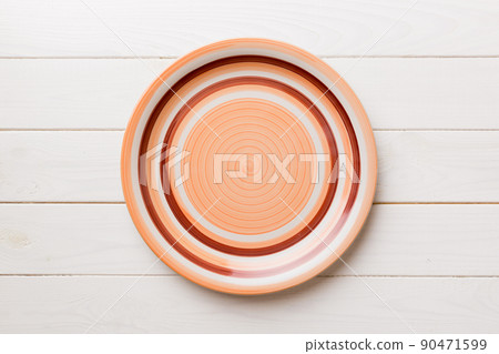 Top view of empty orange plate on wooden background. Empty space for your design 90471599