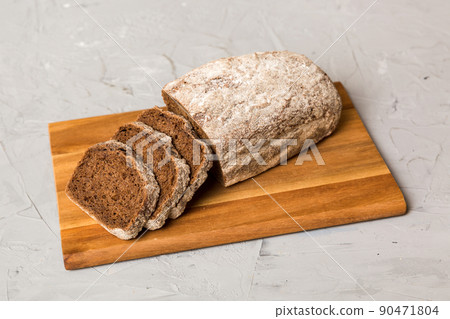 Assortment of freshly sliced baked bread with napkin on rustic table top view. Healthy unleavened bread. French bread slice 90471804