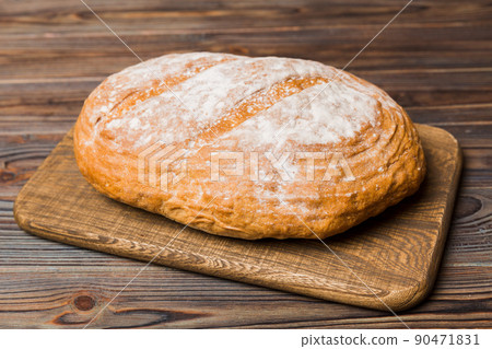 Freshly baked bread on cutting board against white wooden background. perspective view bread with copy space 90471831