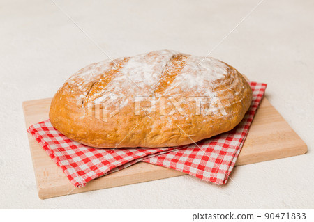 Freshly baked bread on cutting board against white wooden background. perspective view bread with copy space 90471833