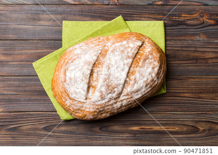 Freshly baked delicious french bread with napkin on rustic table top view. Healthy white bread loaf 90471851