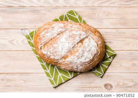 Freshly baked delicious french bread with napkin on rustic table top view. Healthy white bread loaf 90471852
