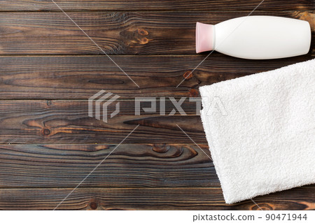 Cosmetic shampoo bottle mockup with towels on a colored table. Bathroom background, toilet accessories for hand and body care Cosmetic shampoo bottle mockup with towels on a colored table. Bathroom background, toilet accessories for hand and body care 90471944