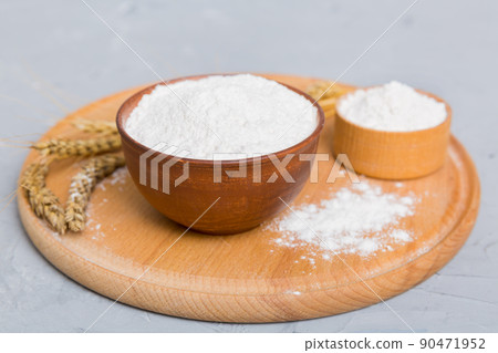 Flat lay of Wheat flour in wooden bowl with wheat spikelets on colored background. world wheat crisis 90471952