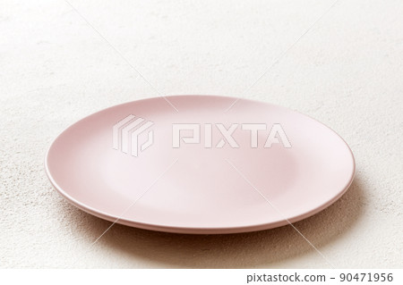 Perspective view of empty pink plate on cement background. Empty space for your design Perspective view of empty pink plate on cement background. Empty space for your design 90471956