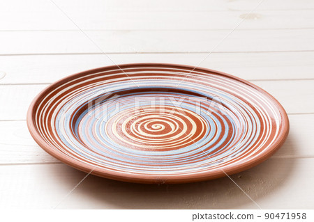 Perspective view of empty colorful plate on wooden background. Empty space for your design 90471958