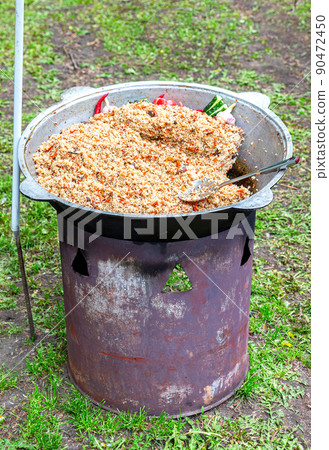 Street food to go - in a large cauldron hot pilaf with pieces of meat Street food to go - in a large cauldron hot pilaf with pieces of meat 90472450
