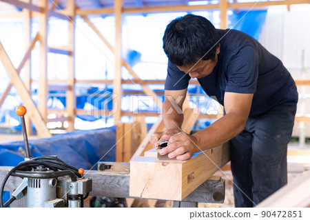 A carpenter who planes wood 90472851
