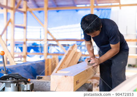 A carpenter who planes wood 90472853