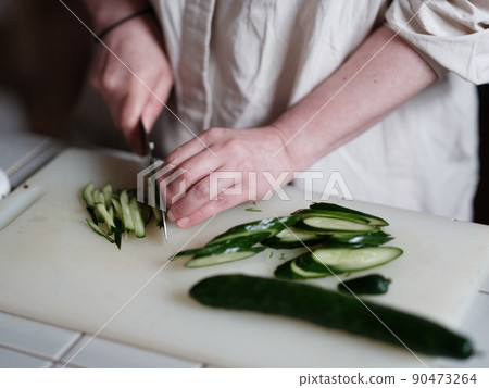A person who cuts cucumbers A person who cuts cucumbers 90473264
