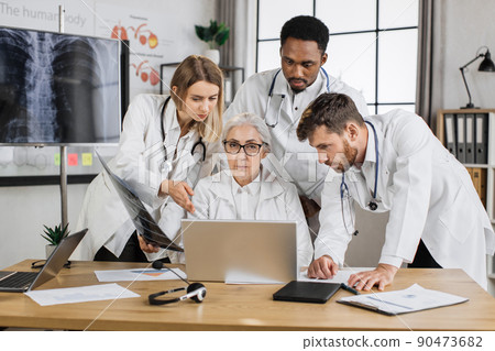 Group of four multiethnic medics having consilium in clinic Group of four multiethnic medics having consilium in clinic 90473682