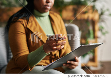 Hand of young confident female psychologist with pen and clipboard Hand of young confident female psychologist with pen and clipboard 90473890