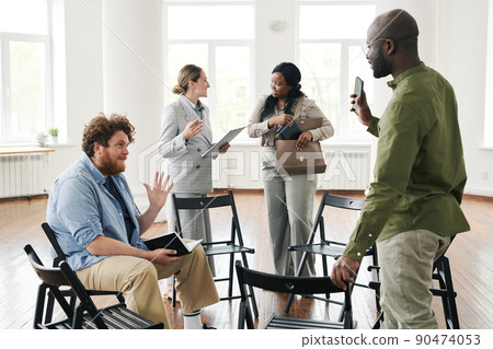 Two young interracial men greeting each other by waving hands before session Two young interracial men greeting each other by waving hands before session 90474053