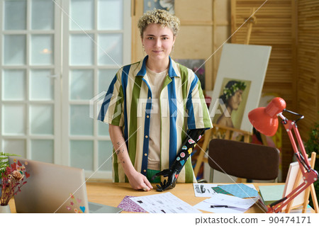 Young female with myoelectric arm decorated with small handmade stickers 90474171