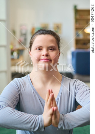 Happy young woman with Down syndrome wearing blue t-shirt while exercising 90474268