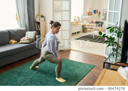 Girl with mental disability doing stretching exercise on the floor at home Girl with mental disability doing stretching exercise on the floor at home 90474276