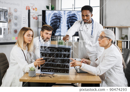 Team of medical workers analysing x ray results on meeting Team of medical workers analysing x ray results on meeting 90474293