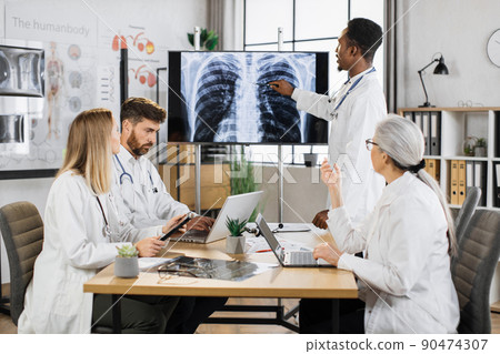 Diverse doctors checking x ray scan of lungs on monitor Diverse doctors checking x ray scan of lungs on monitor 90474307