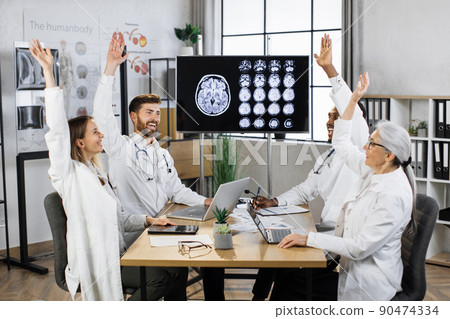 Scientists giving high fives gesture in conference room Scientists giving high fives gesture in conference room 90474334