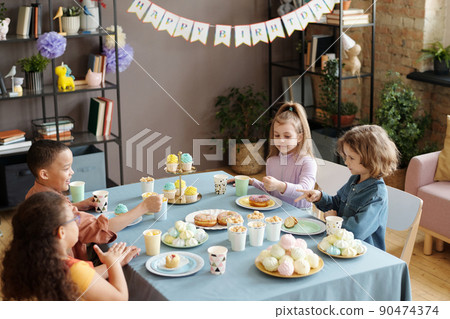 Children enjoying dessert at party Children enjoying dessert at party 90474374