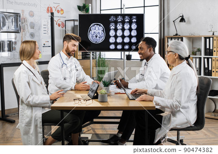 Group of doctors looking at screen with brain CT at hospital 90474382