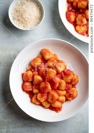 Gnocchi with tomato sauce and parmigiano on a plate Gnocchi with tomato sauce and parmigiano on a plate 90474472