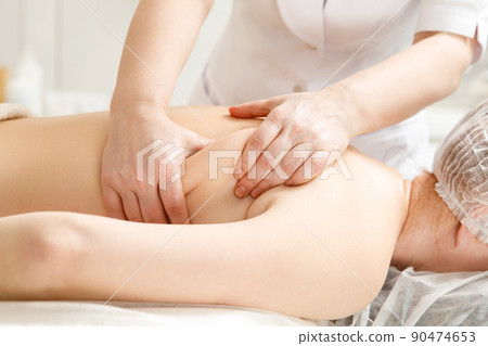 Close up of back massage procedure in spa salon. 90474653