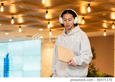 Men in headphones with a laptop Men in headphones with a laptop 90475376