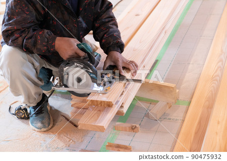 在木屋工地用電鋸和鋼方板加工木材的木匠 在木屋工地用電鋸和鋼方板加工木材的木匠 90475932