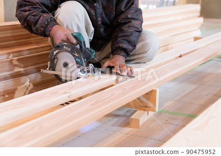 在木屋工地用電鋸和鋼方板加工木材的木匠 在木屋工地用電鋸和鋼方板加工木材的木匠 90475952