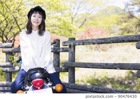 Bike girl image Young woman straddling a motorcycle 90476430