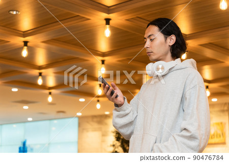 Men with headphones with a smartphone Men with headphones with a smartphone 90476784