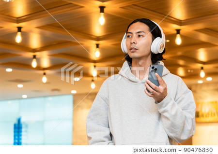 Men with headphones with a smartphone Men with headphones with a smartphone 90476830