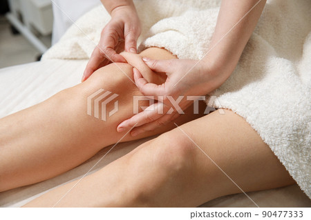 Close up of knee massage procedure in spa salon. 90477333
