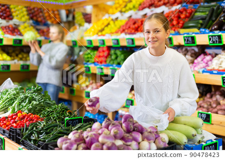 European girl purchaser choosing oranges in a grocery store European girl purchaser choosing oranges in a grocery store 90478423