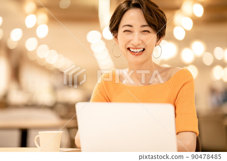 Middle woman using a laptop in a cafe 90478485