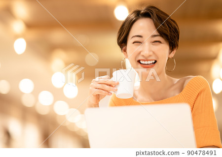Middle woman using a laptop in a cafe 90478491