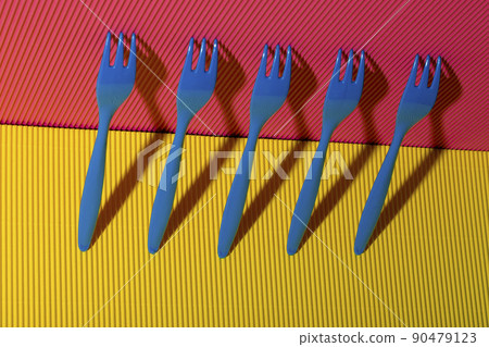 Abstract still life with blue forks on a colored background 90479123