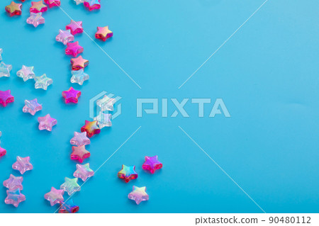 Star beads spilling on a light blue background star 90480112