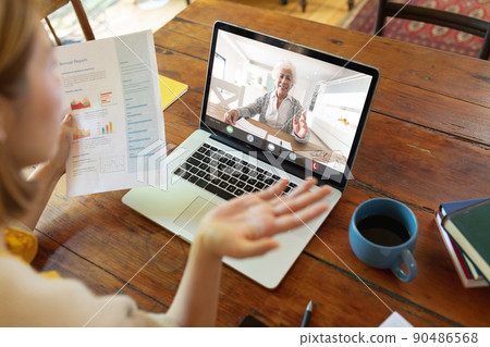 Caucasian young businesswoman gesturing during online meeting with caucasian mature female colleague 90486568