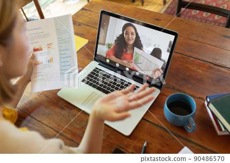 Caucasian young businesswoman gesturing during online meeting with biracial young female colleague 90486570