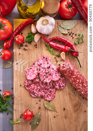 Sliced salami sausage on wooden cutting board at domestic kitchen Sliced salami sausage on wooden cutting board at domestic kitchen 90488779