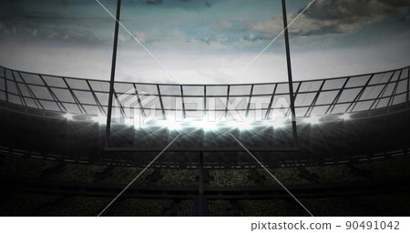 Image of american football goalposts and cloudy sky at floodlit stadium 90491042