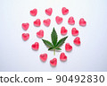 Marijuana and sex concept. Cannabis leaf with heart shaped candies on a grey isolated background 90492830